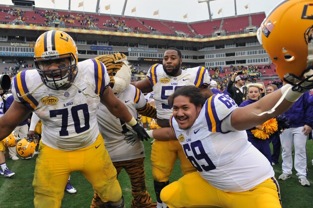 TAMPA, FL -  JANUARY 1:  Offensive linemen Lael Collins #70 and Fehoko Fanaika #69 of the LSU Tigers celebrate after a 21 - 14 victory against the Iowa Hawkeyes January 1, 2014 in the Outback Bowl at Raymond James Stadium in Tampa, Florida.   (Photo by Al Messerschmidt/Getty Images)