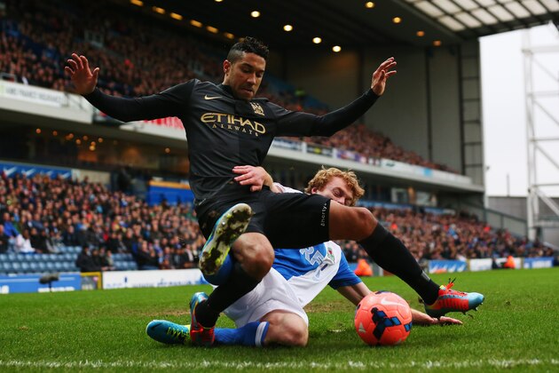 BLACKBURN, ENGLAND - JANUARY 04:  Gael Clichy (L) of Manchester City is tackled by Chris Taylor (R) of Blackburn Rovers during the Budweiser FA Cup third round match between Blackburn Rovers and Manchester City at Ewood Park on January 4, 2014 in Blackburn, England.  (Photo by Alex Livesey/Getty Images)