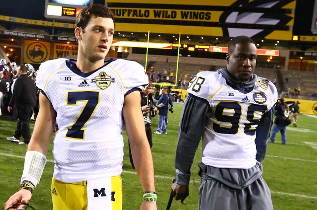 Dec 28, 2013; Tempe, AZ, USA; Michigan Wolverines quarterback Shane Morris (7) walks off the field with  injured quarterback Devin Gardner (98) following the game against the Kansas State Wildcats during the Buffalo Wild Wings Bowl at Sun Devil Stadium. Kansas State defeated Michigan 31-14. Mandatory Credit: Mark J. Rebilas-USA TODAY Sports