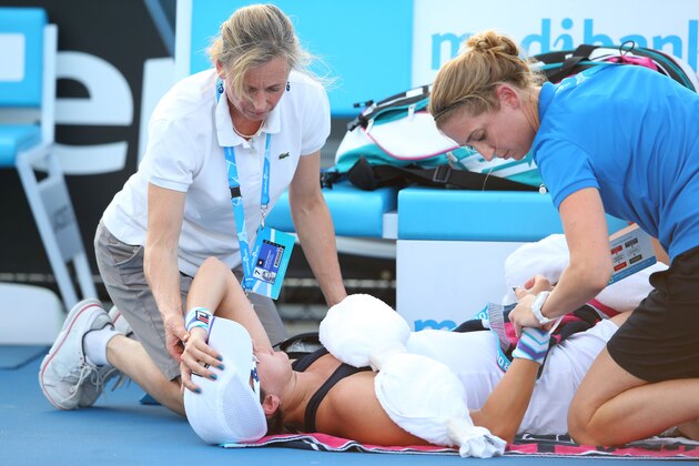MELBOURNE, AUSTRALIA - JANUARY 14:  Yaroslava Shvedova of Kazakhstan is attended to by medical staff in her first round match against Sloane Stephens of the United States during day two of the 2014 Australian Open at Melbourne Park on January 14, 2014 in Melbourne, Australia.  (Photo by Mark Kolbe/Getty Images)