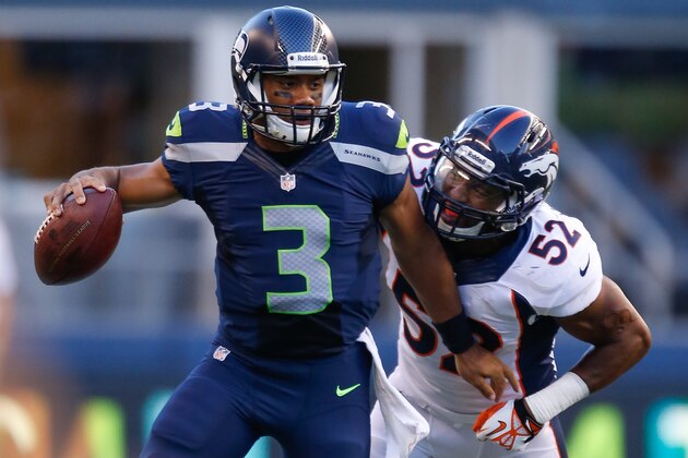 SEATTLE, WA - AUGUST 17:  Quarterback Russell Wilson #3 of the Seattle Seahawks is tackled by linebacker Wesley Woodyard #52 of the Denver Broncos at CenturyLink Field on August 17, 2013 in Seattle, Washington.  (Photo by Otto Greule Jr/Getty Images)