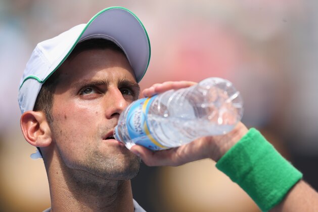 MELBOURNE, AUSTRALIA - JANUARY 15:  Novak Djokovic of Serbia has a drink in his second round match against Leonardo Mayer of Argentina during day three of the 2014 Australian Open at Melbourne Park on January 15, 2014 in Melbourne, Australia.  (Photo by Michael Dodge/Getty Images)
