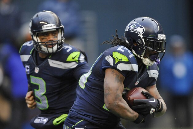 Jan 11, 2014; Seattle, WA, USA; Seattle Seahawks running back Marshawn Lynch (24) receives the hand off from quarterback Russell Wilson (3) against the New Orleans Saints during the second half of the 2013 NFC divisional playoff football game at CenturyLink Field. Mandatory Credit: Steven Bisig-USA TODAY Sports