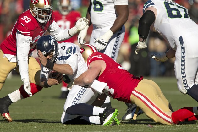SAN FRANCISCO, CA - DECEMBER 08:  Defensive tackle Justin Smith #94 and linebacker Aldon Smith #99 of the San Francisco 49ers sack quarterback Russell Wilson #3 of the Seattle Seahawks in the second quarter on December 8, 2013 at Candlestick Park in San Francisco, California.  The 49ers won 19-17.  (Photo by Brian Bahr/Getty Images)