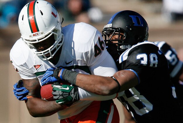 Nov 24, 2012; Durham, NC, USA; Duke Blue Devils safety Jordon Byas (38) tries to strip the ball from Miami Hurricanes tight end Clive Walford (46) during the first half at Wallace Wade Stadium.  Mandatory Credit: Mark Dolejs-USA TODAY Sports