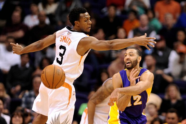 Jan 15, 2014; Phoenix, AZ, USA; Los Angeles Lakers guard Kendall Marshall (12) makes a pass around Phoenix Suns guard Ish Smith (3) in the second half at US Airways Center. The Suns won 121-114. Mandatory Credit: Jennifer Stewart-USA TODAY Sports
