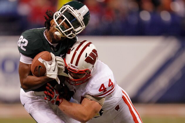 INDIANAPOLIS, IN - DECEMBER 03:  Keshawn Martin #82 of the Michigan State Spartans loses his helmet as he is hit by Chris Borland #44 of the Wisconsin Badgers during the third quarter of the Big 10 Conference Championship Game at Lucas Oil Stadium on December 3, 2011 in Indianapolis, Indiana.  (Photo by Gregory Shamus/Getty Images)