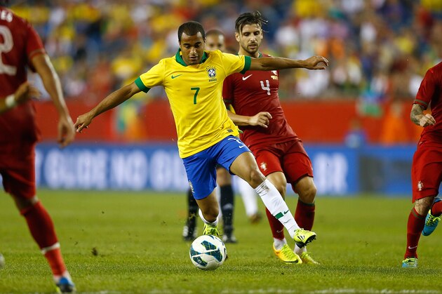 FOXBORO, MA - SEPTEMBER 10: Lucas Moura #7 of Brazil carries the ball past Miguel Veloso #4 of Portugal in the second half during the international friendly match at Gillette Stadium on September 10, 2013 in Foxboro, Massachusetts. (Photo by Jared Wickerham/Getty Images)