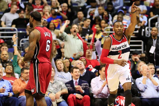 WASHINGTON, DC - JANUARY 15:  John Wall #2 of the Washington Wizards celebrates in front of LeBron James #6 of the Miami Heat after scoring during the first half at Verizon Center on January 15, 2014 in Washington, DC. NOTE TO USER: User expressly acknowledges and agrees that, by downloading and or using this photograph, User is consenting to the terms and conditions of the Getty Images License Agreement.  (Photo by Rob Carr/Getty Images)
