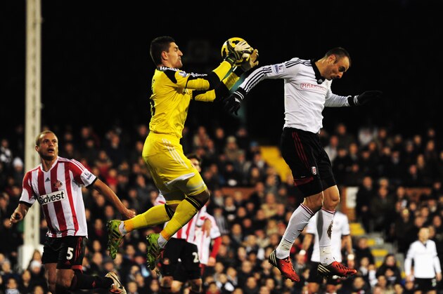 LONDON, ENGLAND - JANUARY 11:  Dimitar Berbatov (R) of Fulham challenges Vito Mannone the Sunderland goalkeeper during the Barclays Premier League match between Fulham and Sunderland at Craven Cottage on January 11, 2014 in London, England.  (Photo by Jamie McDonald/Getty Images)