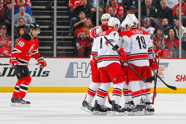 NEWARK, NJ - NOVEMBER 27: Justin Faulk #27 of the Carolina Hurricanes is congratulated by his teammates after scoring a first-period goal as Steve Bernier #18 of the New Jersey Devils skates away during the game at the Prudential Center on November 27, 2013 in Newark, New Jersey. (Photo by Andy Marlin/NHLI via Getty Images)