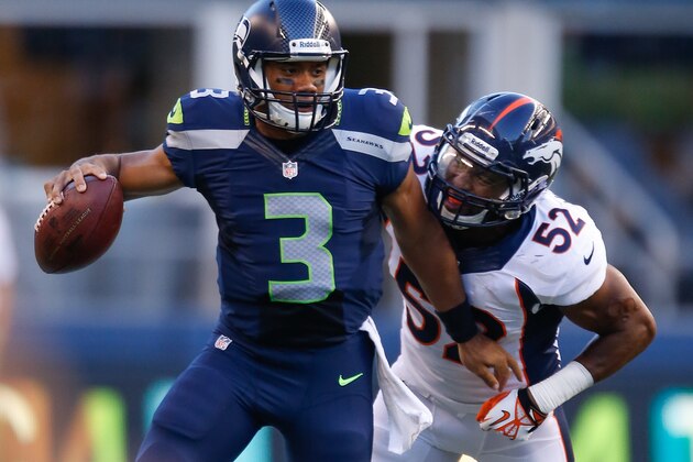 SEATTLE, WA - AUGUST 17:  Quarterback Russell Wilson #3 of the Seattle Seahawks is tackled by linebacker Wesley Woodyard #52 of the Denver Broncos at CenturyLink Field on August 17, 2013 in Seattle, Washington.  (Photo by Otto Greule Jr/Getty Images)