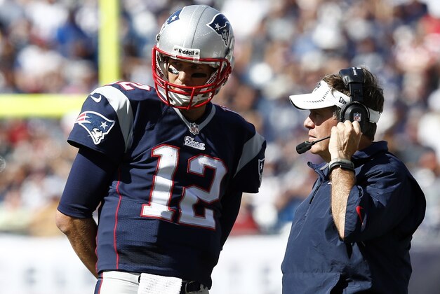 Sep 22, 2013; Foxborough, MA, USA; New England Patriots head coach Bill Belichick (right) speaks to quarterback Tom Brady (12) during the first half of  a game against the Tampa Bay Buccaneers at Gillette Stadium. Mandatory Credit: Mark L. Baer-USA TODAY Sports