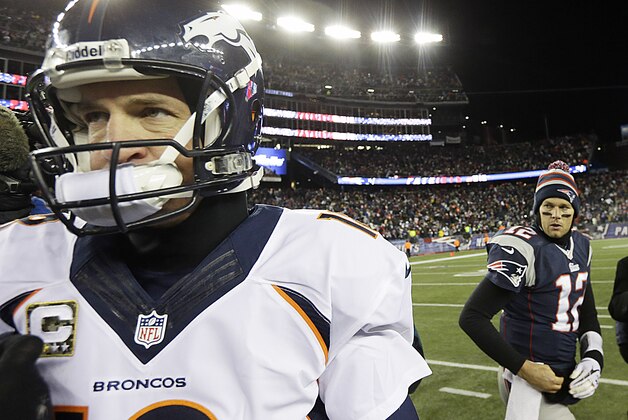 Denver Broncos quarterback Peyton Manning (18) heads toward the locker room after shaking hands with New England Patriots quarterback Tom Brady (12) after losing in overtime of an NFL football game, Monday, Nov. 25, 2013, in Foxborough, Mass. The Patriots defeated the Broncos 34-31. (AP Photo/Steven Senne)