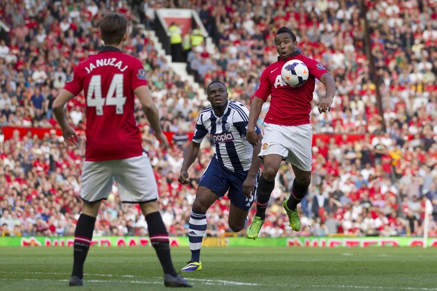 Manchester United's Anderson, right, chests the ball as West Bromwich Albion's Victor Anichebe, centre, looks on during their English Premier League soccer match at Old Trafford Stadium, Manchester, England, Saturday Sept. 28, 2013. (AP Photo/Jon Super)