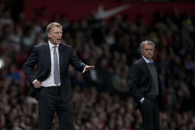 Manchester United's manager David Moyes, left, directs proceedings as he stands alongside Chelsea's manager Jose Mourinho during their English Premier League soccer match at Old Trafford Stadium, Manchester, England, Monday Aug. 26, 2013. (AP Photo/Jon Super)