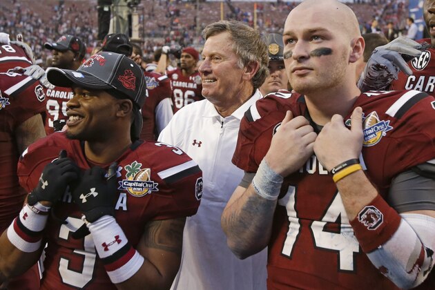 South Carolina wide receiver Nick Jones (3) and quarterback Connor Shaw (14) stand with coach Steve Spurrier, center, in front of the school band and listen to the alma mater after South Carolina defeated Wisconsin 34-24 in the Capital One Bowl NCAA college football game in Orlando, Fla., Wednesday, Jan. 1, 2014. (AP Photo/John Raoux)