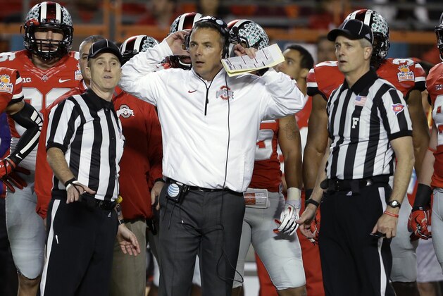 Ohio State coach Urban Meyer stands with officials as they wait for a ruling on the field during the first half of the Orange Bowl NCAA college football game against Clemson, Friday, Jan. 3, 2014, in Miami Gardens, Fla. (AP Photo/Lynne Sladky)