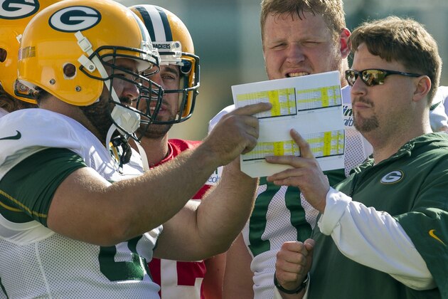 Green Bay Packers quarterbacks coach Ben McAdoo, Center Jeff Saturday (63), quarterback Aaron Rodgers (12) and offensive guard T.J. Lang, from left, talk (70) during NFL football training camp Saturday, July. 28, 2012, in Green Bay, Wis. (AP Photo/Mike Roemer)