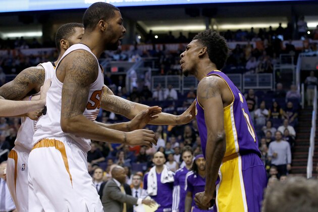 Los Angeles Lakers' Nick Young, right, has words with Phoenix Suns' Marcus Morris and Markieff Morris, rear, during the first half of an NBA basketball game Wednesday, Jan. 15, 2014, in Phoenix. Young was ejected from the game along with Suns' Alex Len. (AP Photo/Ross D. Franklin)