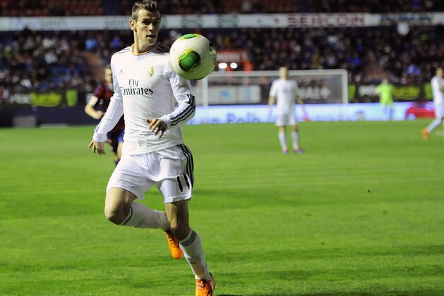 Real Madrid's Gareth Bale of Wales goes for the ball during their Spanish Copa del Rey round-16 second leg soccer match between Osasuna and Real Madrid , at El Sadar stadium, in Pamplona northern Spain on Wednesday, Jan. 15, 2014. (AP Photo/Alvaro Barrientos)