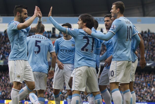 Manchester City's Edin Dzeko, right, celebrates with teammates after scoring against Cardiff City during their English Premier League soccer match at the Etihad Stadium, Manchester, England, Saturday Jan 18, 2014. (AP Photo/Jon Super)