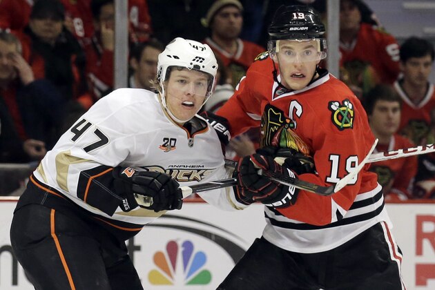 Chicago Blackhawks' Jonathan Toews, right, and Anaheim Ducks' Hampus Lindholm watch the puck during the second period of an NHL hockey game in Chicago, Friday, Jan. 17, 2014. (AP Photo/Nam Y. Huh)