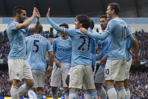 Manchester City's Edin Dzeko, right, celebrates with teammates after scoring against Cardiff City during their English Premier League soccer match at the Etihad Stadium, Manchester, England, Saturday Jan 18, 2014. (AP Photo/Jon Super)