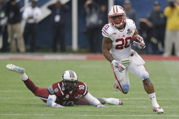 Wisconsin running back James White (20) gains yardage as he breaks away from South Carolina linebacker Skai Moore (10)during the first half of the Capital One Bowl NCAA college football game in Orlando, Fla., Wednesday, Jan. 1, 2014.(AP Photo/John Raoux)