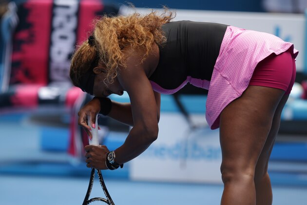 Serena Williams of the U.S. supports herself with a racket as she plays Ana Ivanovic of Serbia during their fourth round match at the Australian Open tennis championship in Melbourne, Australia, Sunday, Jan. 19, 2014.(AP Photo/Aaron Favila)