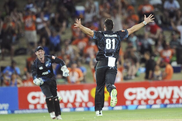 New Zealand's Mitchell McClenaghan (81) runs towards Luke Ronchi after he took the catch off his bowling to dismiss India’s MS Dhoni for 40 in their first one day international cricket match at McLean Park in Napier, New Zealand, Sunday, Jan. 19, 2014. (AP Photo/SNPA, Ross Setford) NEW ZEALAND OUT