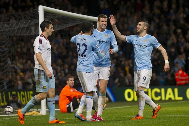 Manchester City's Edin Dzeko, centre right, celebrates with teammates after scoring against West Ham during their English League Cup semi-final soccer match at the Etihad Stadium, Manchester, England, Wednesday Jan. 8, 2014. (AP Photo/Jon Super)