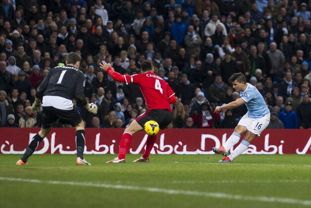Manchester City's Sergio Aguero, right, scores past Cardiff City's David Marshall, left, as Steven Caulker, centre, stands helpless during their English Premier League soccer match at the Etihad Stadium, Manchester, England, Saturday Jan 18, 2014. (AP Photo/Jon Super)