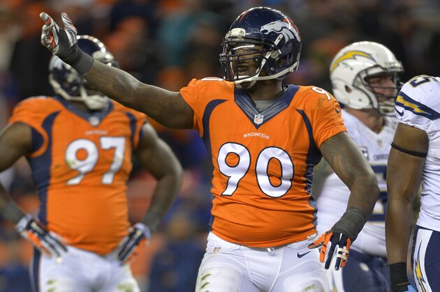 Denver Broncos defensive end Shaun Phillips (90) motions to teammates against the San Diego Chargers in the fourth quarter  of an NFL AFC division playoff football game, Sunday, Jan. 12, 2014, in Denver. (AP Photo/Jack Dempsey)