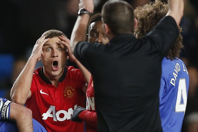 Manchester United's Nemanja Vidic reacts as referee Phil Dowd shows him a red card during the English Premier League soccer match against Chelsea at Stamford Bridge, London, Sunday, Jan. 19, 2014. (AP Photo/Sang Tan)
