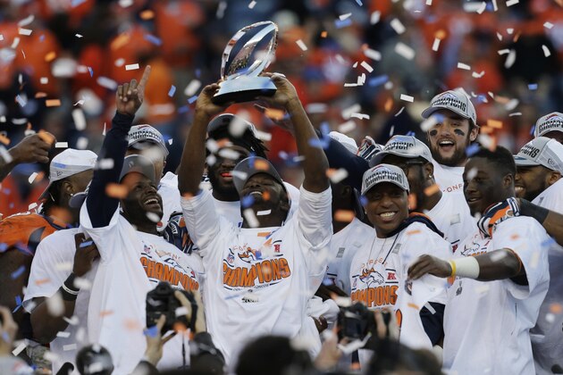 The Denver Broncos celebrate with the trophy after the AFC Championship NFL playoff football game against the New England Patriots in Denver, Sunday, Jan. 19, 2014. The Broncos defeated the Patriots 26-16 to advance to the Super Bowl. (AP Photo/Julie Jacobson)