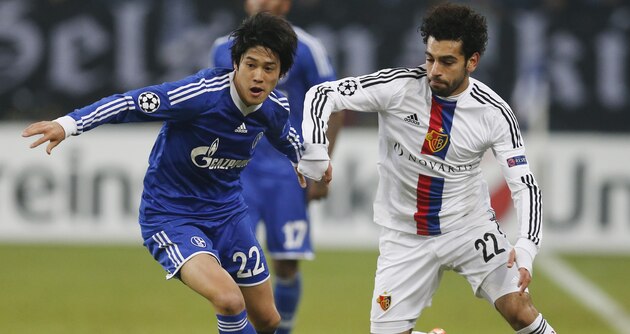 Schalke's Atsuto Uchida, left, and Basel's Mohamed Salah challenge for the ball during the Champions League group E soccer match between FC Schalke 04 and FC Basel in Gelsenkirchen, Germany, Wednesday, Dec.11,2013. (AP Photo/Frank Augstein)