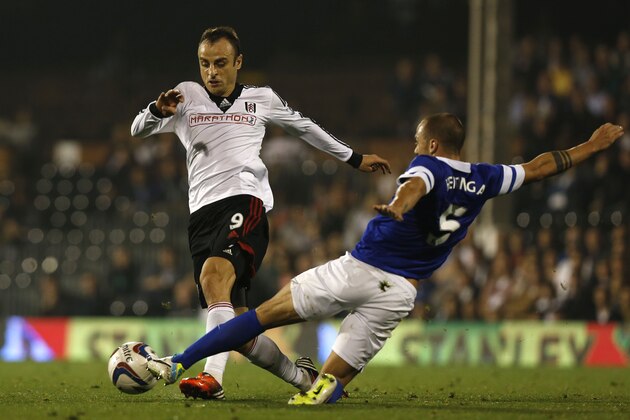 Fulham's Dimitar Berbatov, left, is tackled by Everton's John Heitinga during their English League Cup third round soccer match at Craven Cottage, London, Tuesday, Sept. 24, 2013. (AP Photo/Sang Tan)