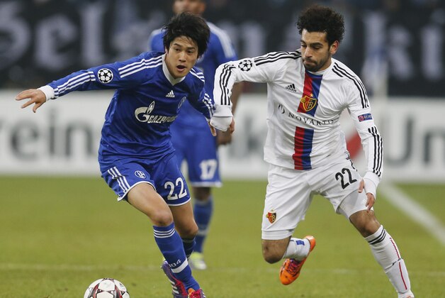 Schalke's Atsuto Uchida, left, and Basel's Mohamed Salah challenge for the ball during the Champions League group E soccer match between FC Schalke 04 and FC Basel in Gelsenkirchen, Germany, Wednesday, Dec.11,2013. (AP Photo/Frank Augstein)