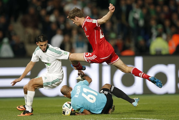 Bayern's Thomas Mueller, top, leaps over Raja Casablanca's goalkeeper Khalid Askri during the final of the soccer Club World Cup  between FC Bayern Munich and Raja Casablanca in Marrakech, Morocco, Saturday, Dec. 21, 2013. (AP Photo/Christophe Ena)