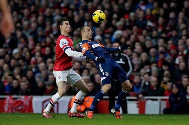 Arsenal's Laurent Koscielny competes for the ball with Fulham's Dimitar Berbatov, right, during the English Premier League soccer match between Arsenal and Fulham at the Emirates Stadium in London, Saturday, Jan. 18, 2014.  (AP Photo/Matt Dunham)