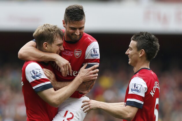 Arsenal's Per Mertesacker, left, celebrates with teammates Oliver Giroudafter, centre, and Laurent Koscielny after scoring the second goal against Stoke during the English Premier League soccer match between Arsenal and Stoke City at Emirates Stadium in London, Sunday, Sept. 22, 2013. (AP Photo/Sang Tan)