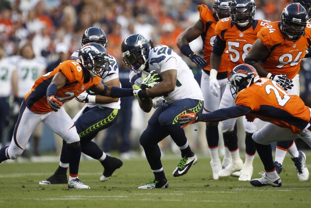 Denver Broncos safety Rahim Moore,left, joins safety Mike Adams, right, in stopping Seattle Seahawks runningback Marshawn Lynch in the first half of an NFL football preseason game, Saturday, Aug. 18, 2012, in Denver. (AP Photo/David Zalubowski)