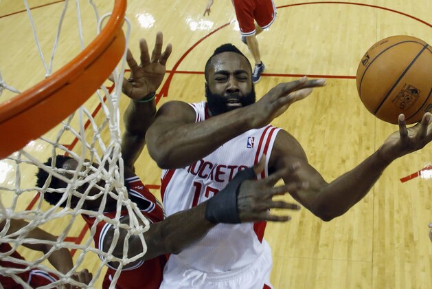 Houston Rockets' James Harden, center, is fouled by Milwaukee Bucks' Larry Sanders, left, during the first quarter of an NBA basketball game Saturday, Jan. 18, 2014, in Houston. (AP Photo/David J. Phillip)