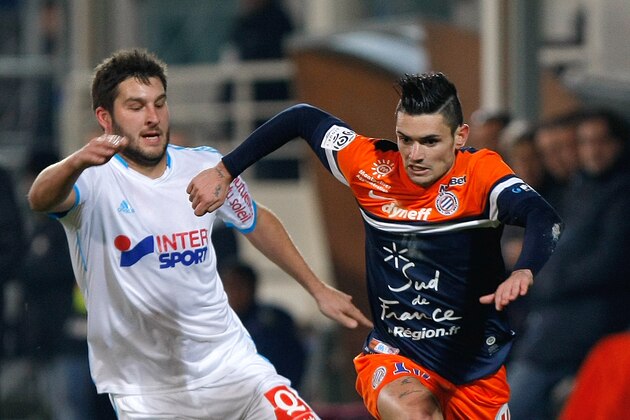 Montpellier's French midfielder Remy Cabella, right, challenges for the ball with Marseille's French forward Andre-Pierre Gignac, during their League One soccer match, at the Velodrome Stadium, in Marseille, southern France, Friday, Nov. 29, 2013. (AP Photo/Claude Paris)