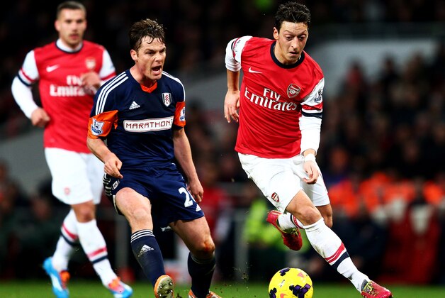LONDON, ENGLAND - JANUARY 18:  Mesut Oezil of Arsenal evades Scott Parker of Fulham during the Barclays Premier League match between Arsenal and Fulham at Emirates Stadium on January 18, 2014 in London, England.  (Photo by Clive Mason/Getty Images)
