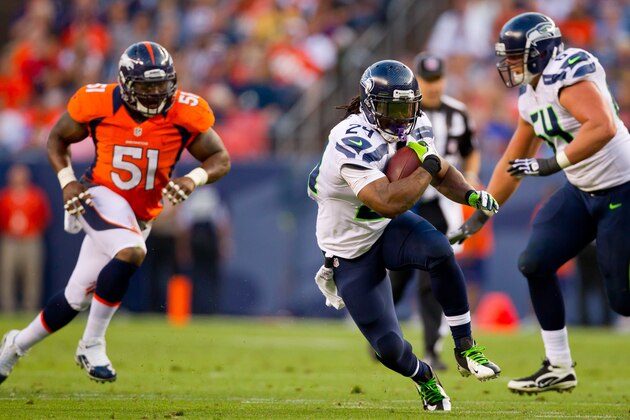 DENVER, CO - AUGUST 18:  Running back Marshawn Lynch #24 of the Seattle Seahawks runs through a hole for a first down as linebacker Joe Mays #51 of the Denver Broncos gives chase and offensive guard J.R. Sweezy #64 looks to make a block during the first quarter at Sports Authority Field Field at Mile High on August 18, 2012 in Denver, Colorado. (Photo by Justin Edmonds/Getty Images)