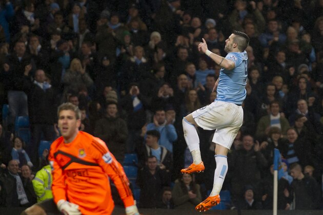 Manchester City's Alvaro Negredo celebrates after scoring his third goal past West Ham's goalkeeper Adrian, left, during their English League Cup semi-final soccer match at the Etihad Stadium, Manchester, England, Wednesday Jan. 8, 2014. (AP Photo/Jon Super)