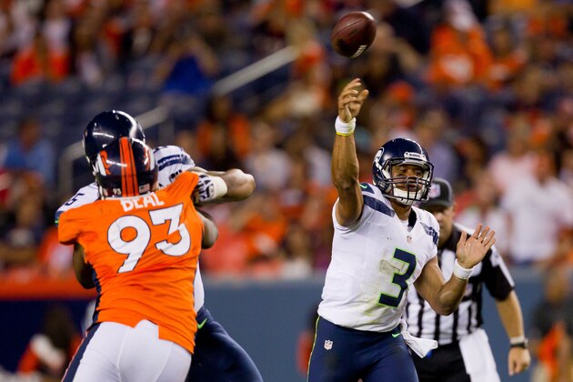 DENVER, CO - AUGUST 18:  Quarterback Russell Wilson #3 of the Seattle Seahawks throws a pass for a completion as defensive end Jeremy Beal #93 of the Denver Broncos applies pressure during the fourth quarter at Sports Authority Field Field at Mile High on August 18, 2012 in Denver, Colorado. The Seahawks defeated the Broncos 30-10.  (Photo by Justin Edmonds/Getty Images)