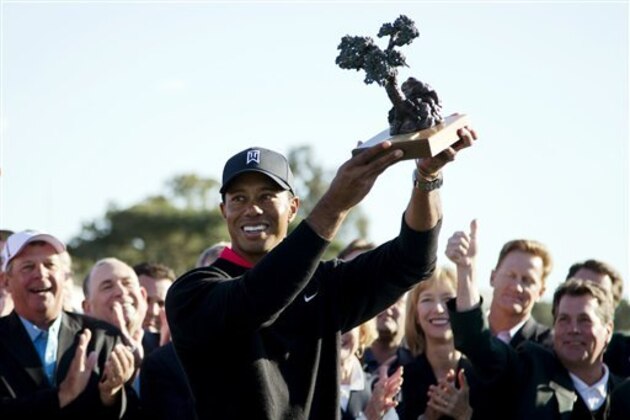 Tiger Woods holds up the trophy after winning the Farmers Insurance Open golf tournament at the Torrey Pines Golf Course, Monday, Jan. 28, 2013, in San Diego. Woods closed with an even-par 72 for a four-shot victory. (AP Photo/Gregory Bull)